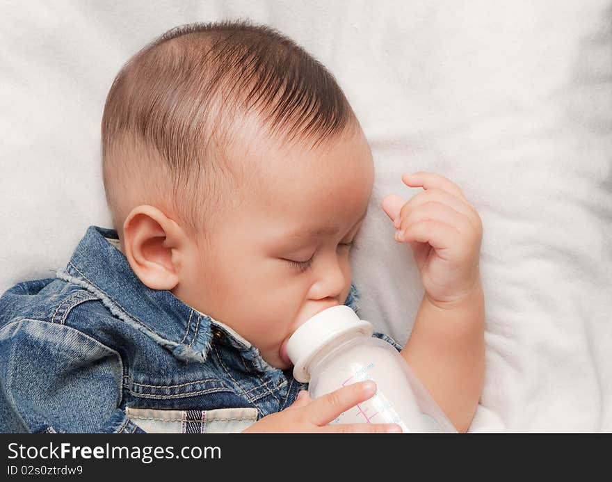 Asian boy sleeping and hold his milk bottle. Asian boy sleeping and hold his milk bottle