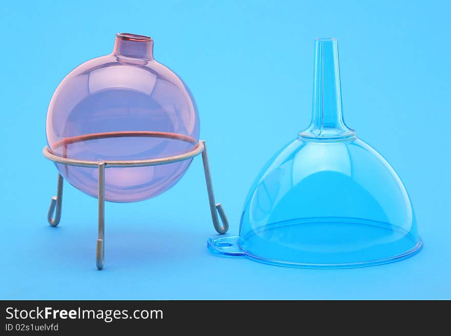 Flask and funnel on a blue background in laboratory