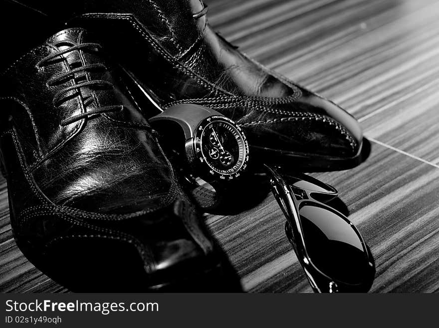 Dress shoes and a watch in the spotlight (focus on watch)