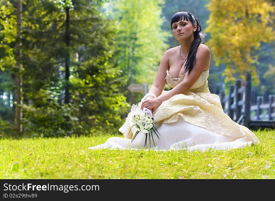 Beautiful Bride rest on the grass on her wedding day