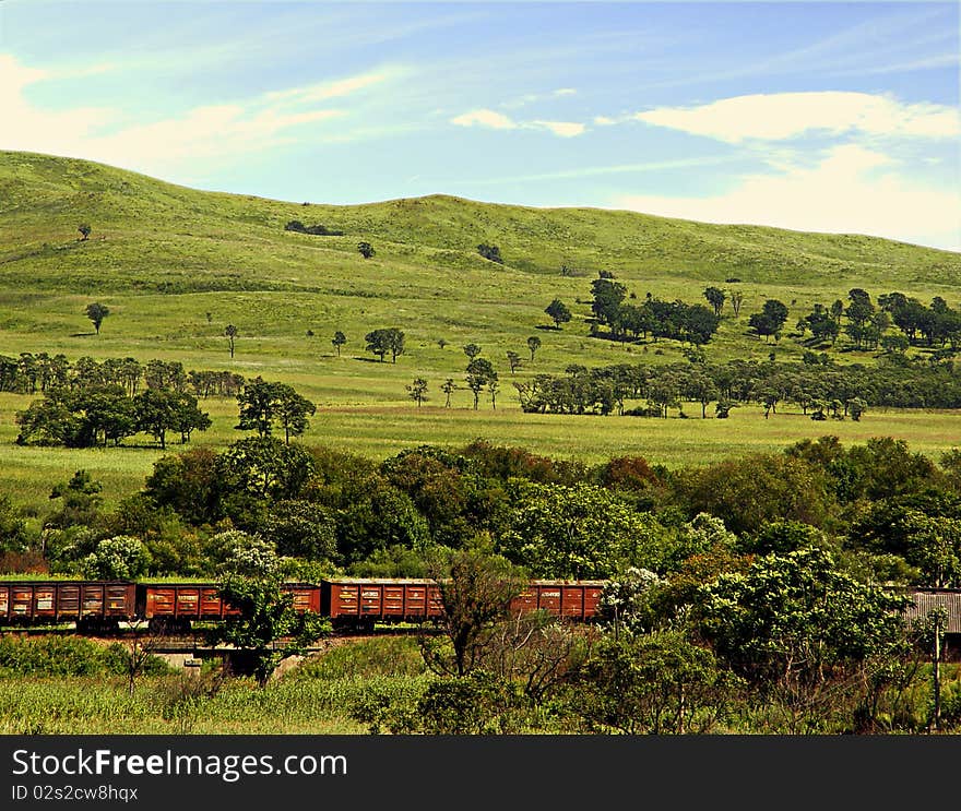 Red train going on a valley. Red train going on a valley