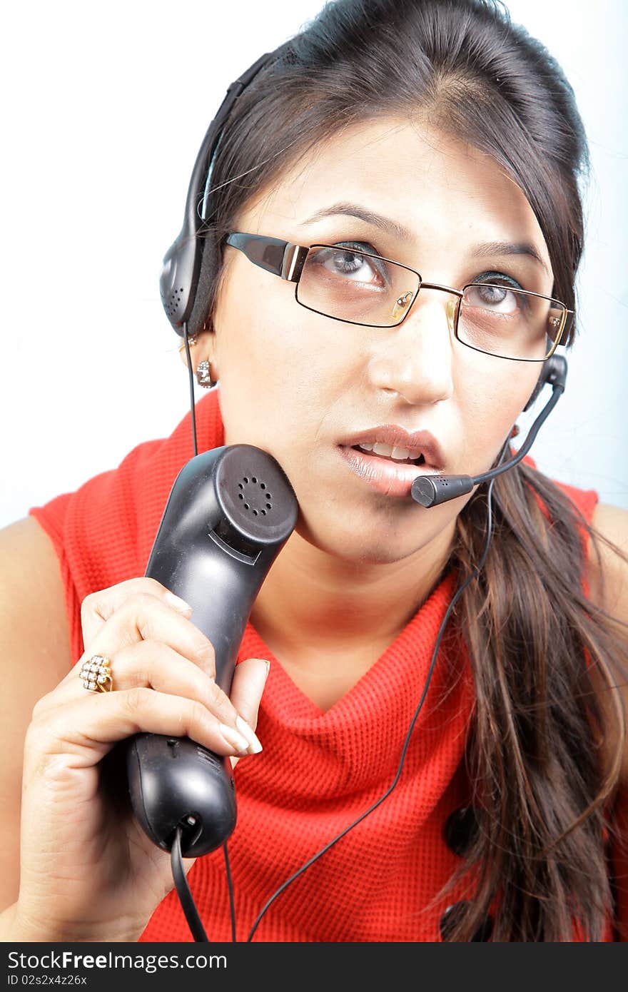 Busy call center executive on white background, asian woman.