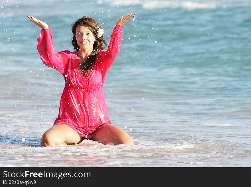 Beautiful Girl In Water Drops On Beach