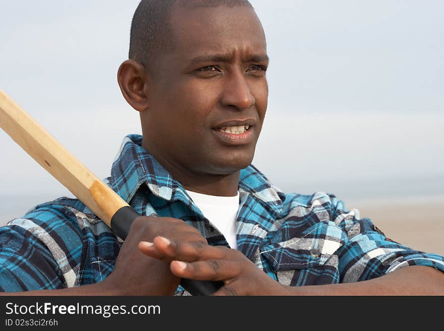 Young Man Playing Cricket On Autumn Beach Holiday in the sun. Young Man Playing Cricket On Autumn Beach Holiday in the sun