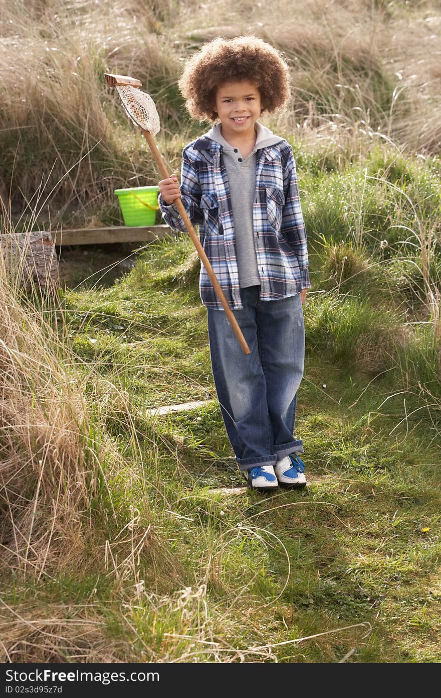 Young Boy Carrying Fishing Net At Seaside