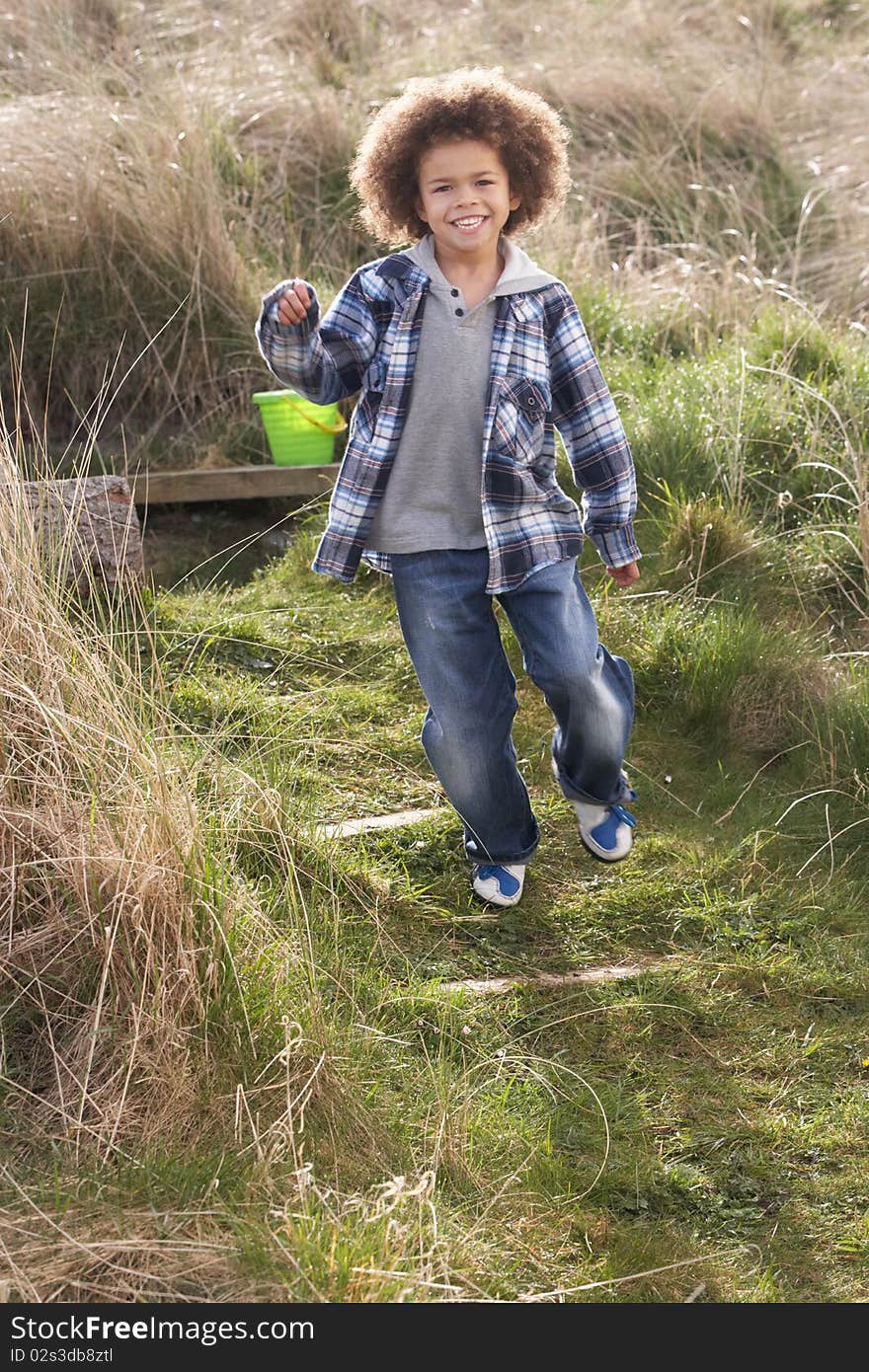 Young Boy Carrying Fishing Net At Seaside