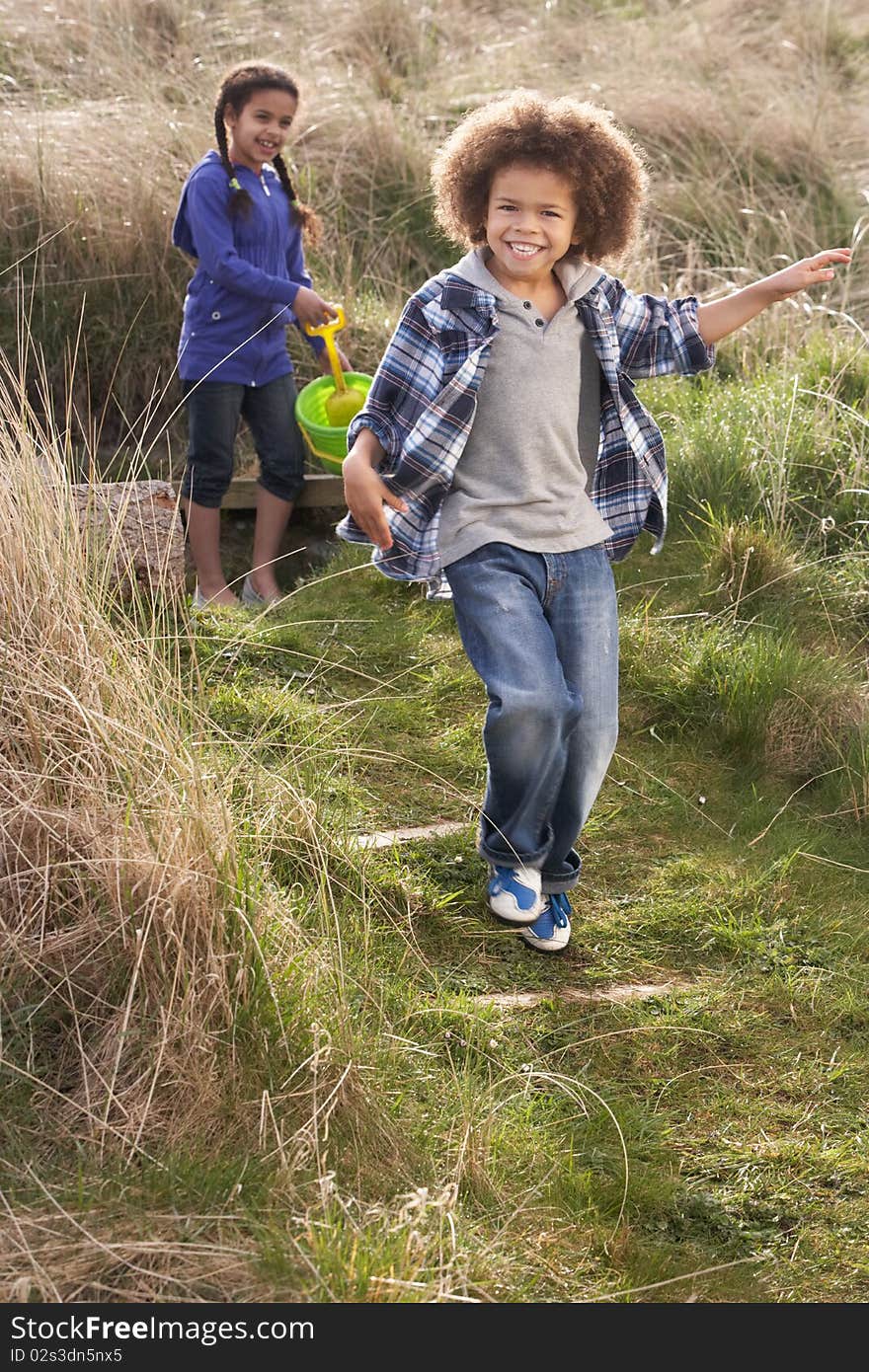 Young Children Carrying Fishing Net At Seaside in the sun