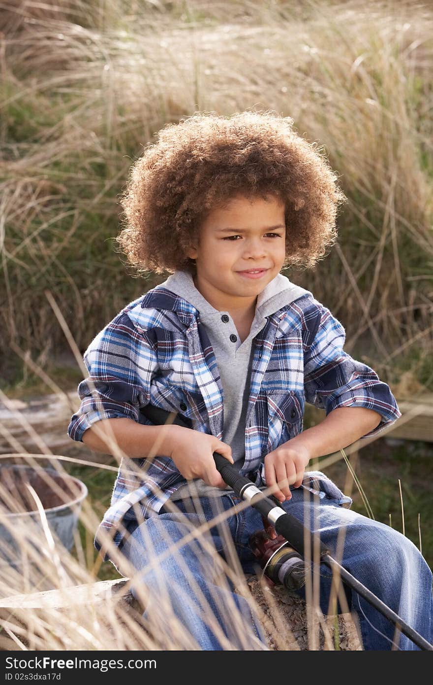 Young Boy Fishing At Seaside