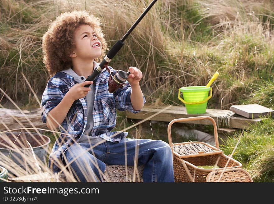 Young Boy Fishing At Seaside