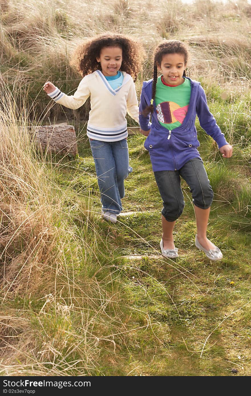 Young Girls Playing In Field Together