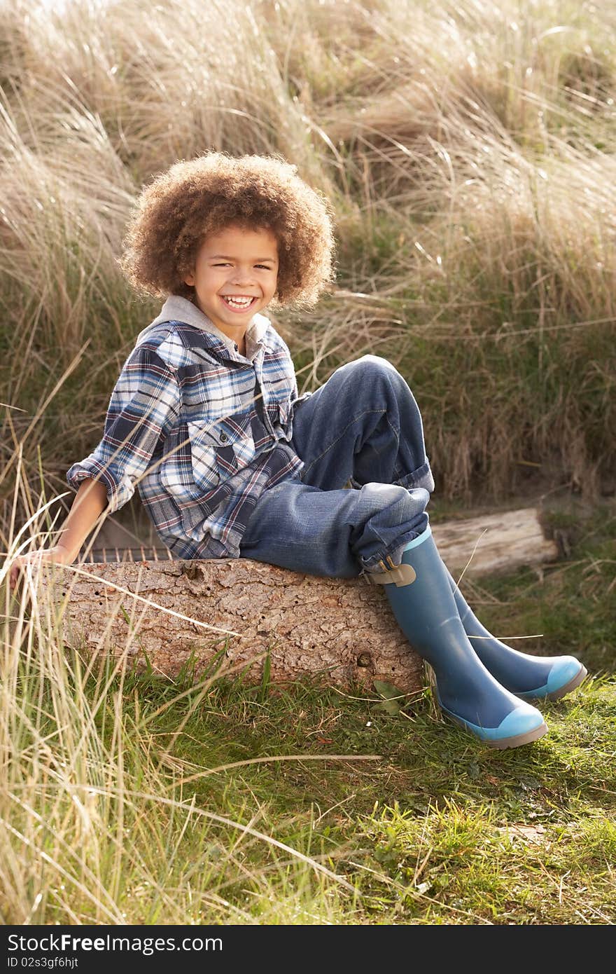 Young Boy Putting On Wellington Boots