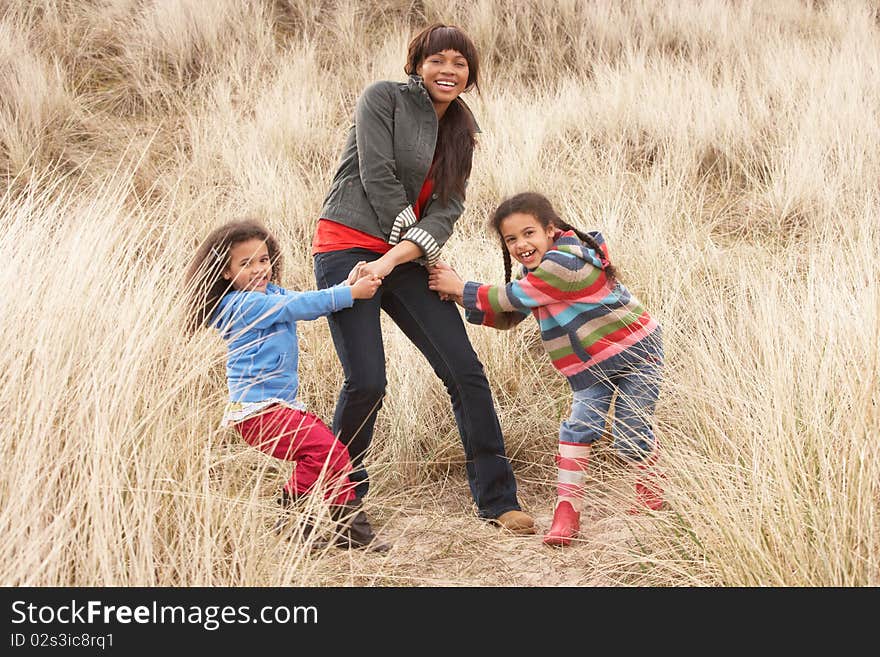 Mother And Daughters Having Fun In Sand Dunes in the sun