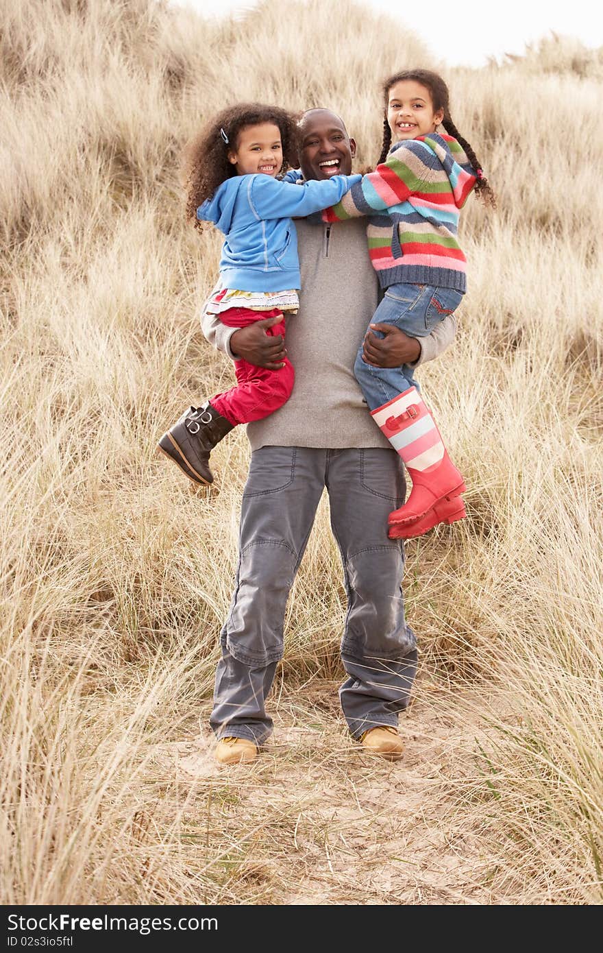 Father And Daughters Having Fun In Sand Dunes in the sun