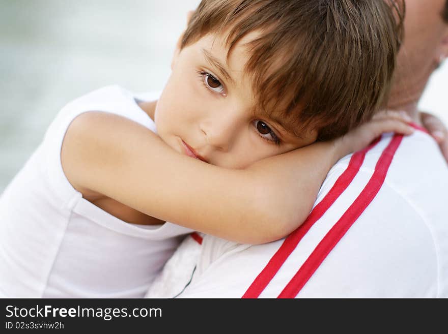 Portrait of little beautiful boy having rest on father's hands, outdoor shot. Portrait of little beautiful boy having rest on father's hands, outdoor shot