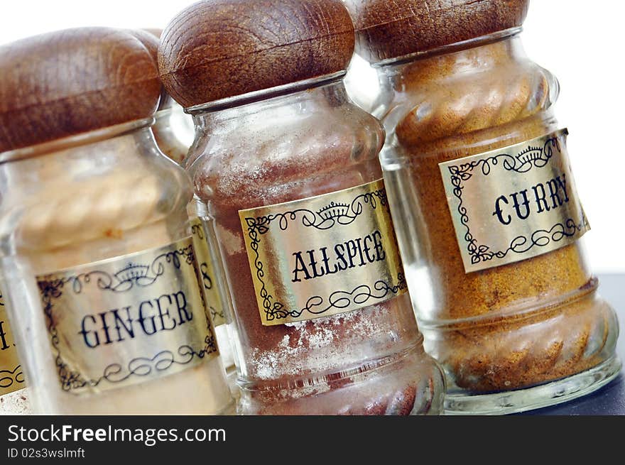 A variety of different spices on a black counter top.