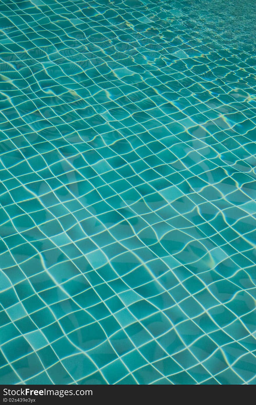 Background of rippled pattern of water in a green swimming pool