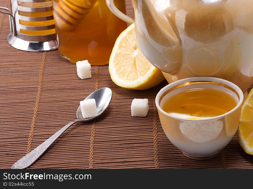 Tea, pot and honey on table