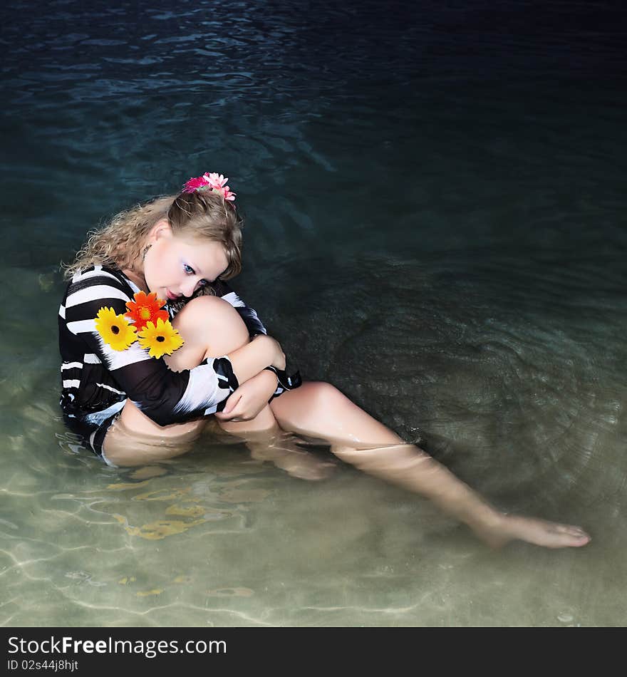 Beautiful woman with flowers in the sea. Beautiful woman with flowers in the sea