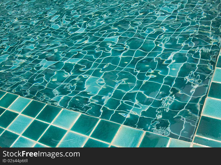 Background of rippled pattern of water in a green swimming pool