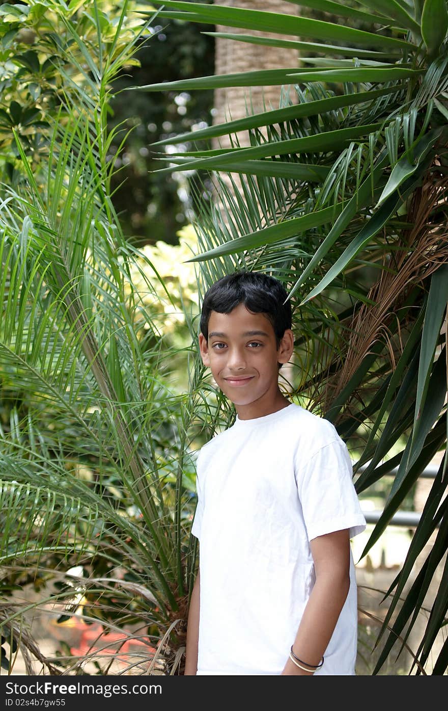 Portrait of a smiling boy in the background of tropical plants. Portrait of a smiling boy in the background of tropical plants.