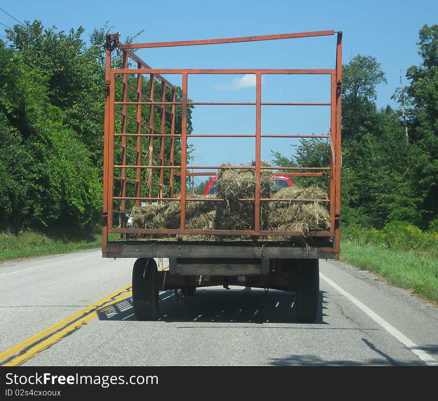 A hay wagon going down the highway