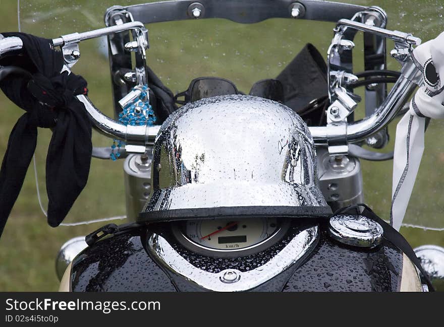 Detail of the front view of the motorbike with chrome helmet on the tank. Detail of the front view of the motorbike with chrome helmet on the tank.