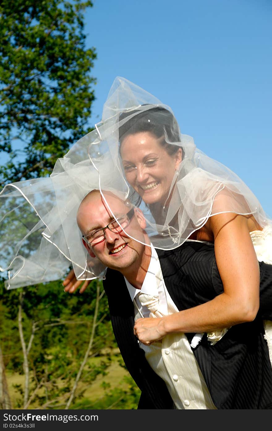 Groom is lifting his bride up in a park. Groom is lifting his bride up in a park.