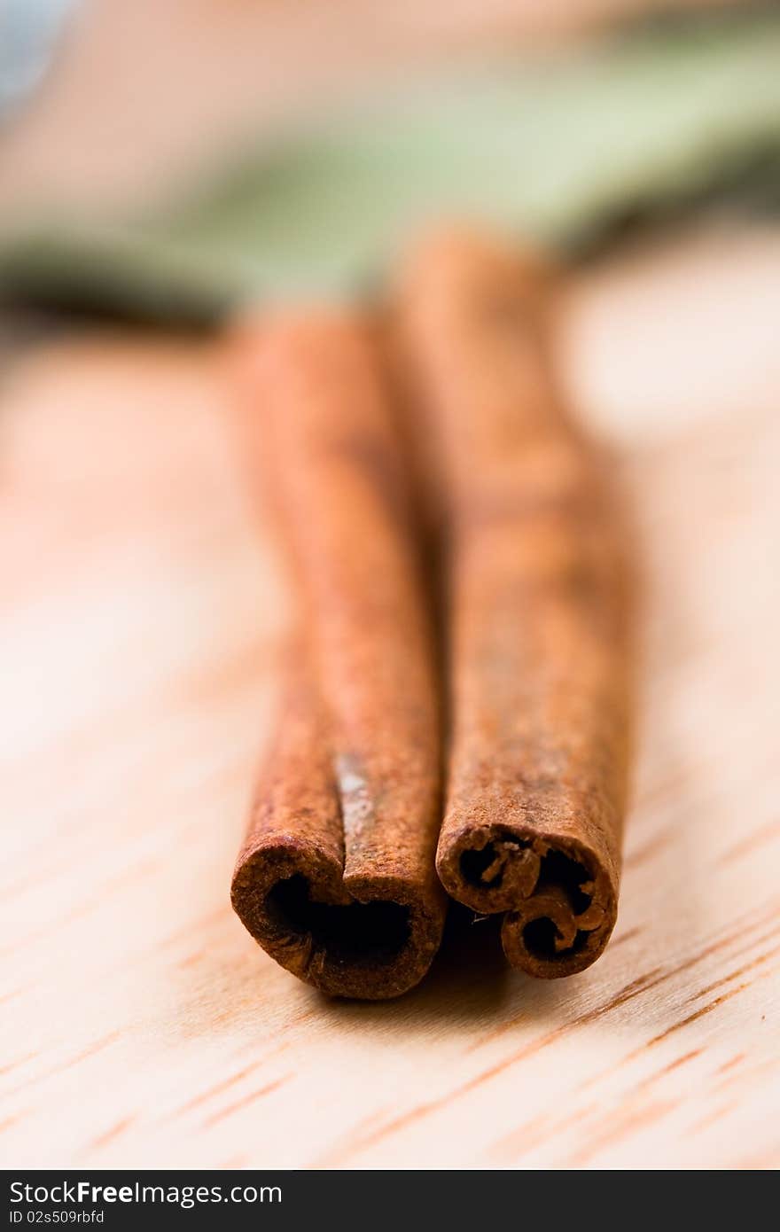 Two cinnamon sticks closeup on wooden background