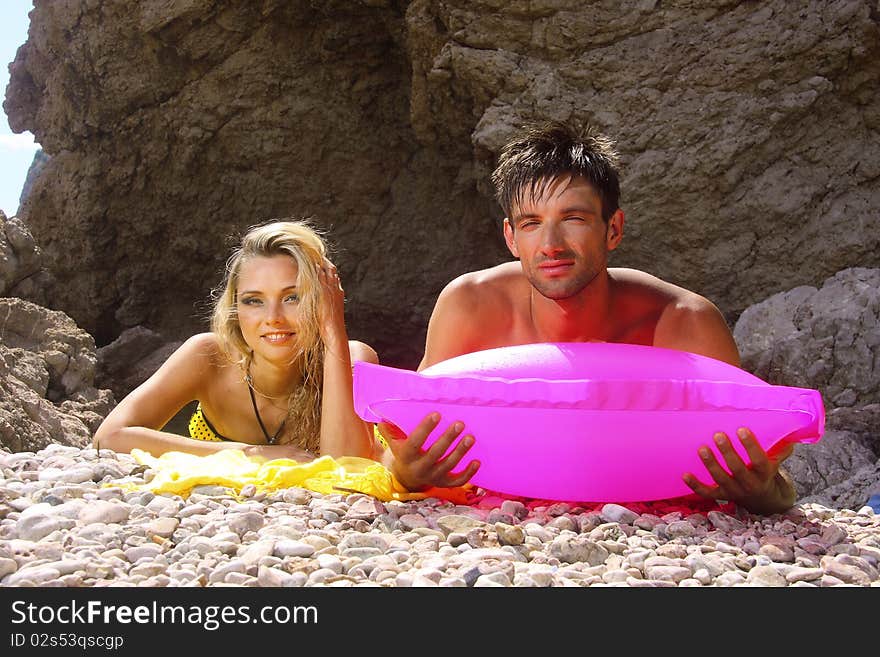 Married couple on a beach of pebbles near the rocks