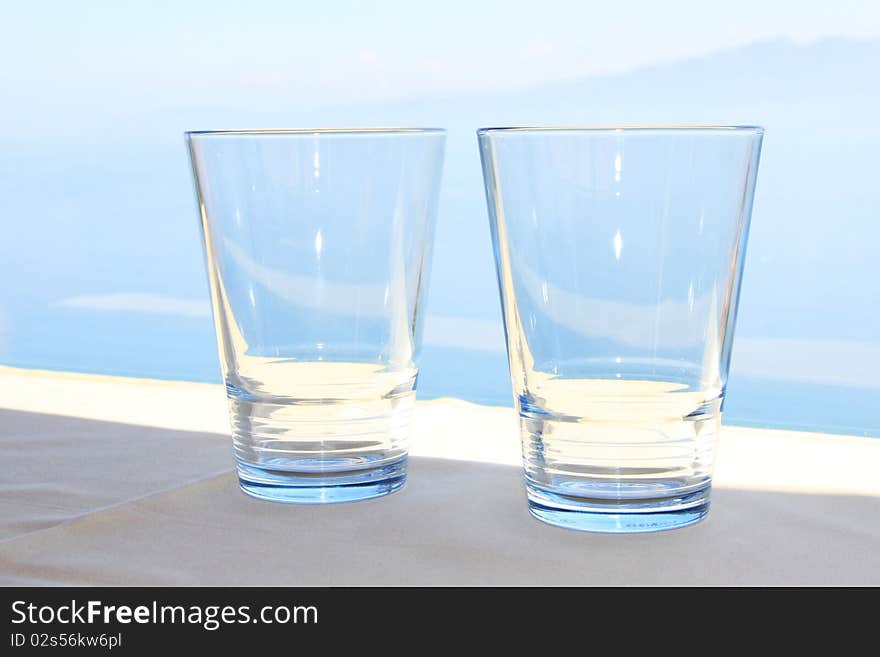 Two blue water glasses in front de blue sea. Two blue water glasses in front de blue sea