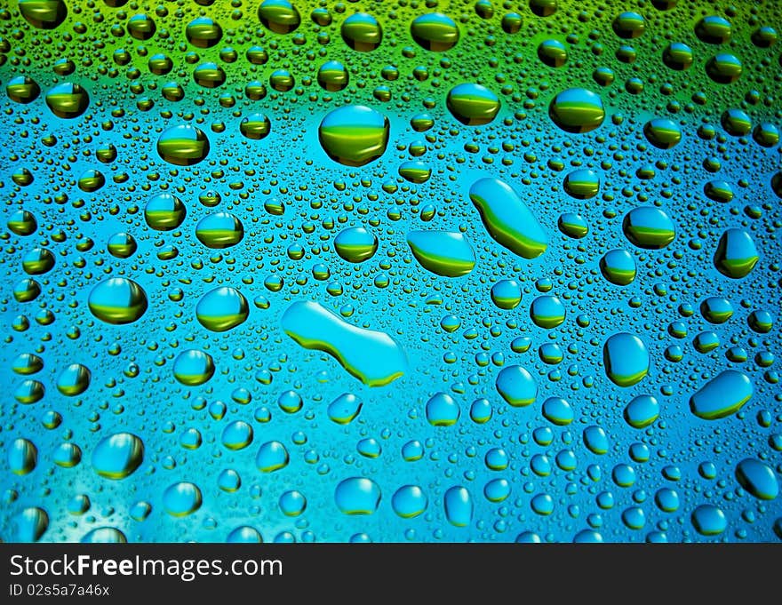 Many little water drops on the glass(yellow,blue). Many little water drops on the glass(yellow,blue)