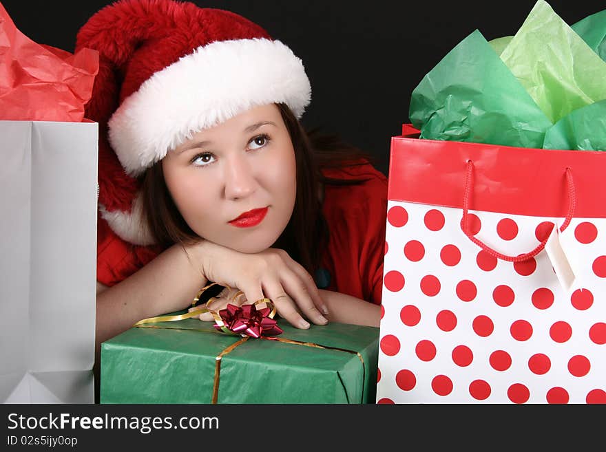 Beautiful caucasian brunette dreaming about christmas amongst gifts. Beautiful caucasian brunette dreaming about christmas amongst gifts