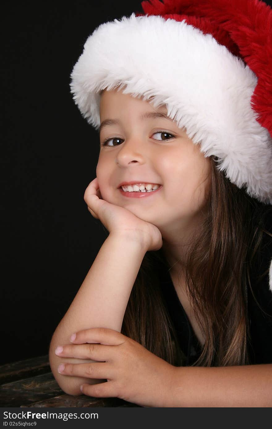 Cute little brunette girl wearing a christmas hat. Cute little brunette girl wearing a christmas hat