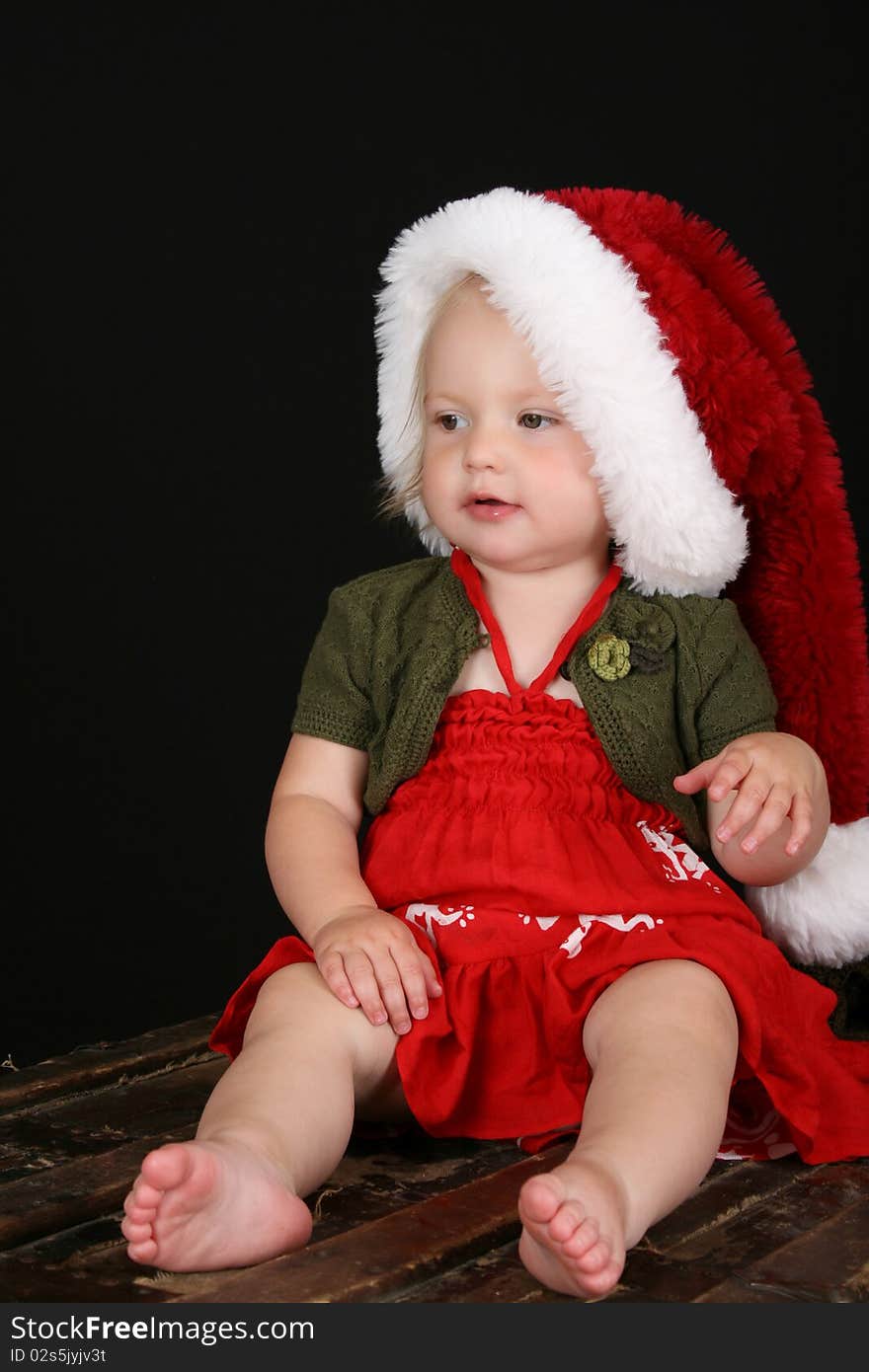 Cute blond girl wearing a red dress and christmas hat. Cute blond girl wearing a red dress and christmas hat