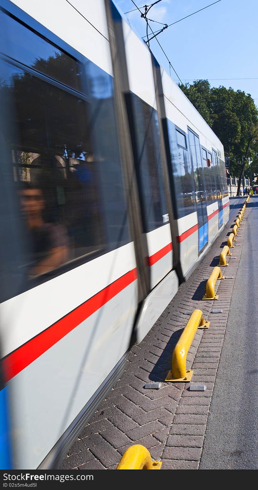 Overland metro electric metro train travelling down a street with motion blur