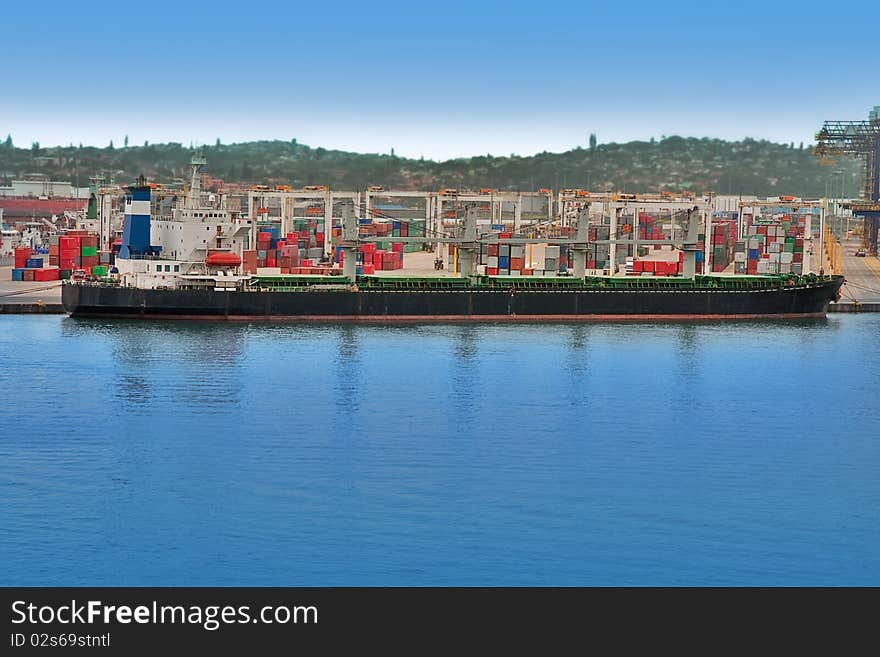 Huge container ship docked in harbor with containers in background. Huge container ship docked in harbor with containers in background