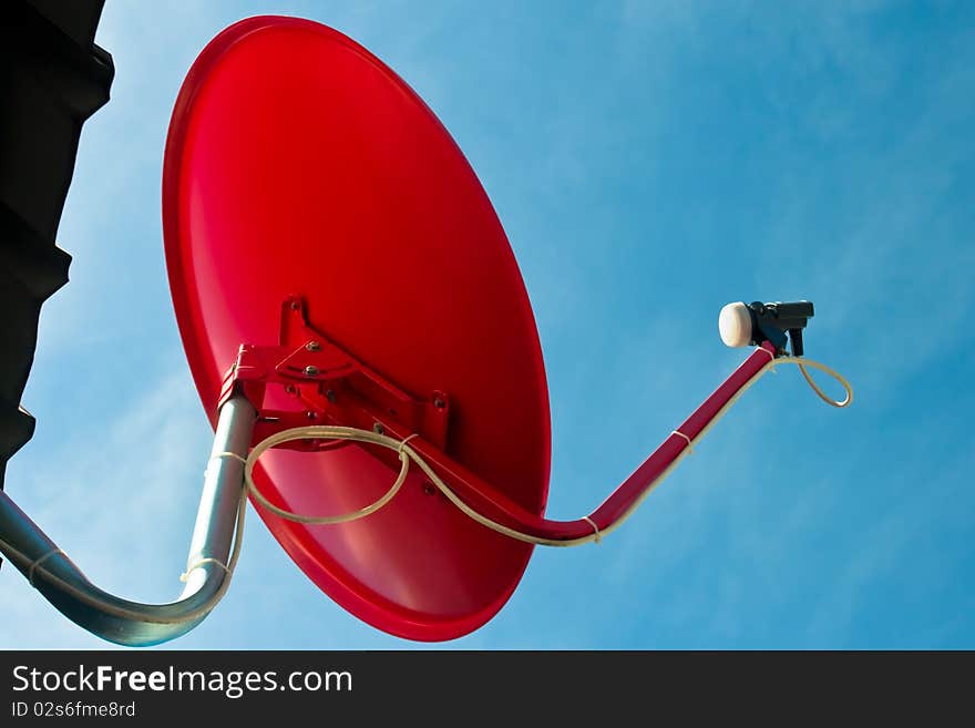 Red satellite dish with blue sky