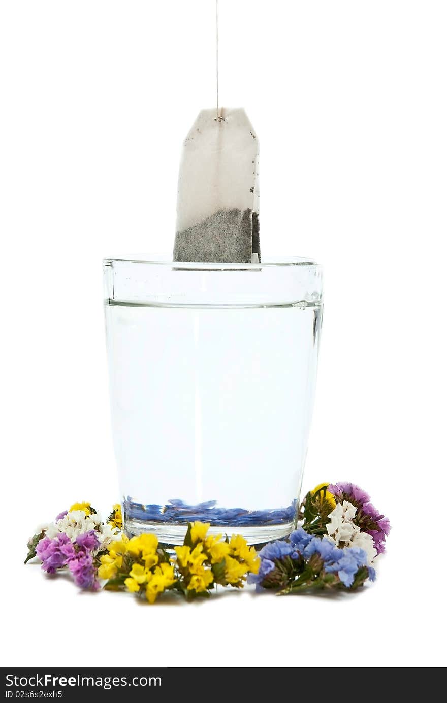 Preparing tea in glass cup with flowers. Isolated on white background