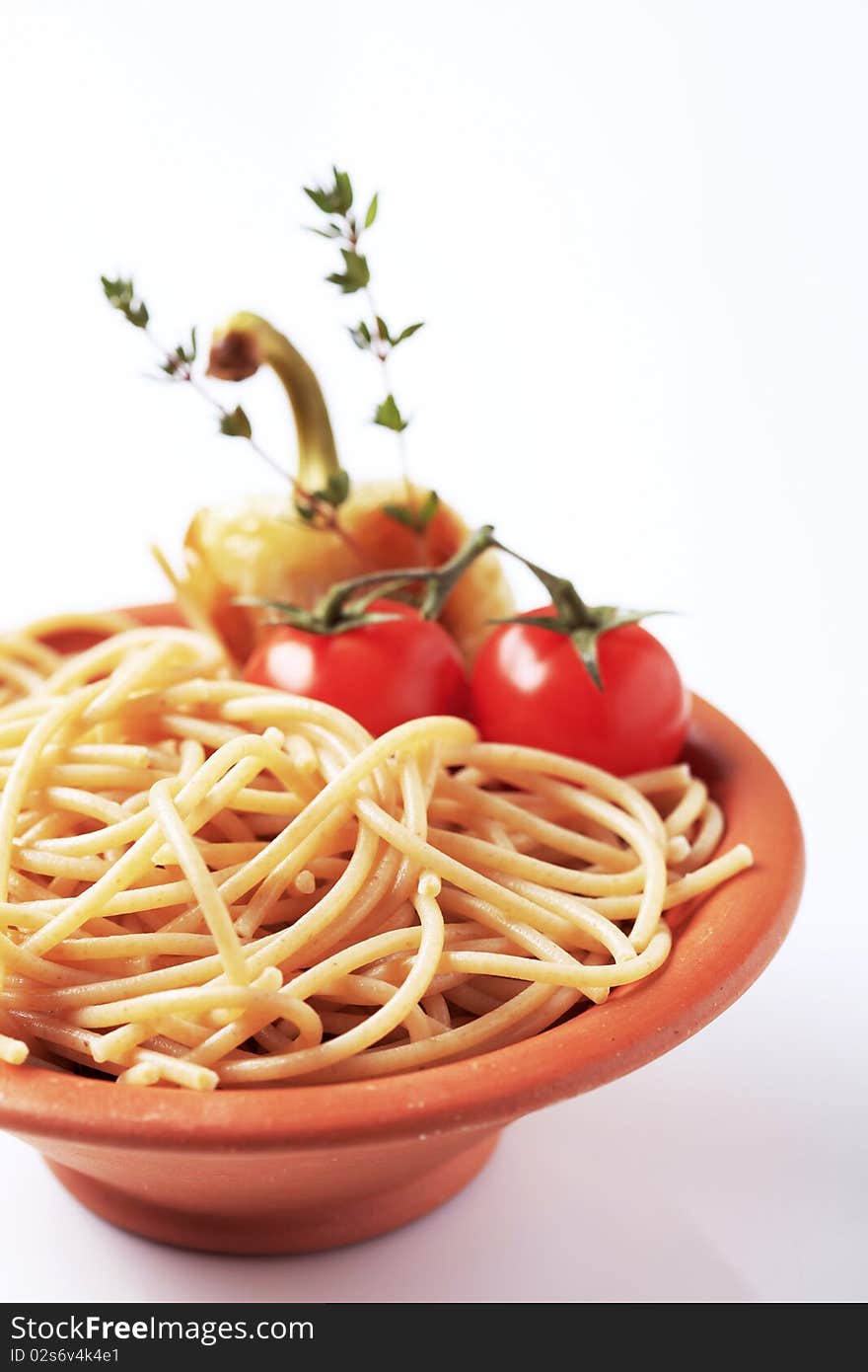 Cooked whole wheat spaghetti in a terracotta bowl