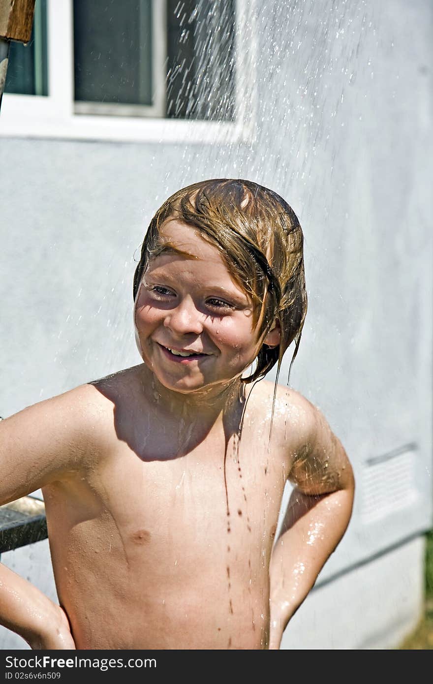 Child has a refreshing shower in the heat