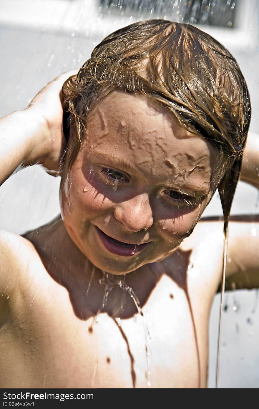 Child has a refreshing shower in the heat