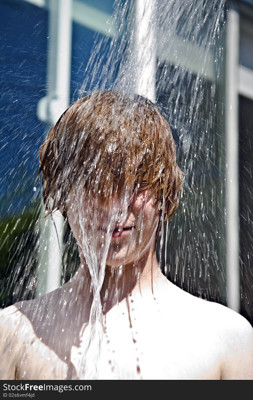 Child has a refreshing shower in the heat