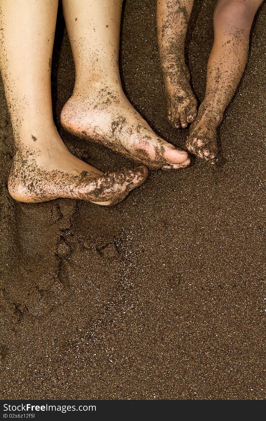 Feet of ethnic mother and baby relaxing on the beach at vacation and holidays. Feet of ethnic mother and baby relaxing on the beach at vacation and holidays