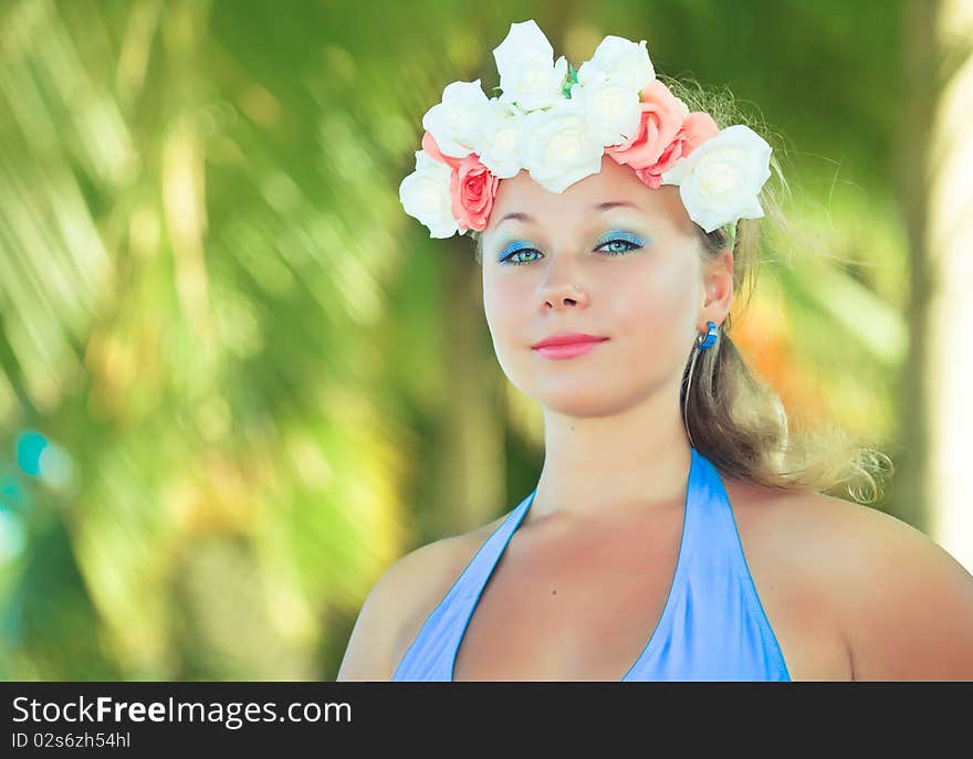 Woman in flower diadem on the beach