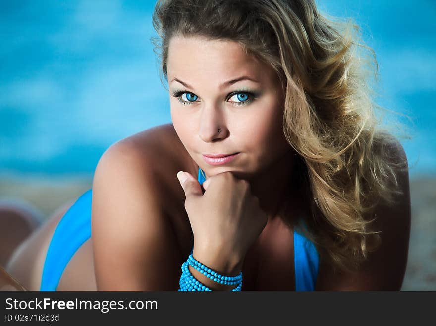 Young beautiful woman sunbathing on the sand