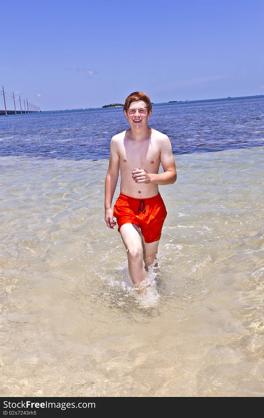 Boy runs along the beach of the wonderful clear ocean. Boy runs along the beach of the wonderful clear ocean