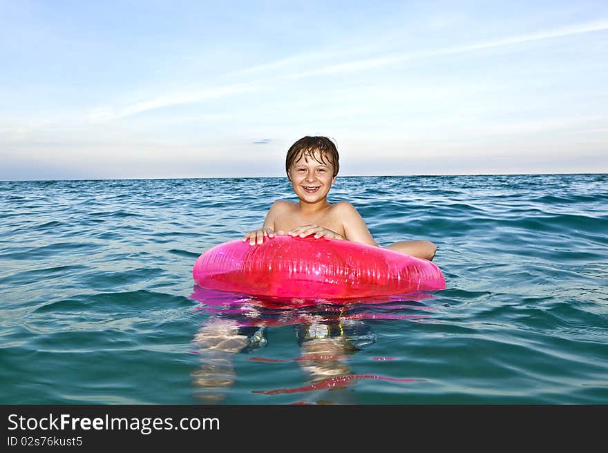 Brothers in a swim ring have fun in the ocean