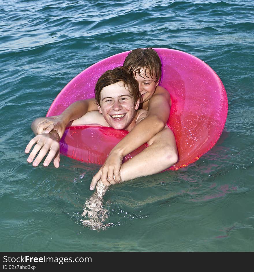 Brothers In A Swim Ring Have Fun In The Ocean