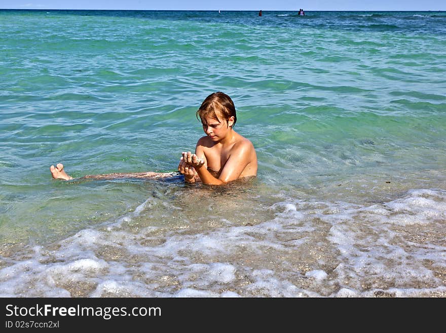 Boy enjoys the clear water in the ocean