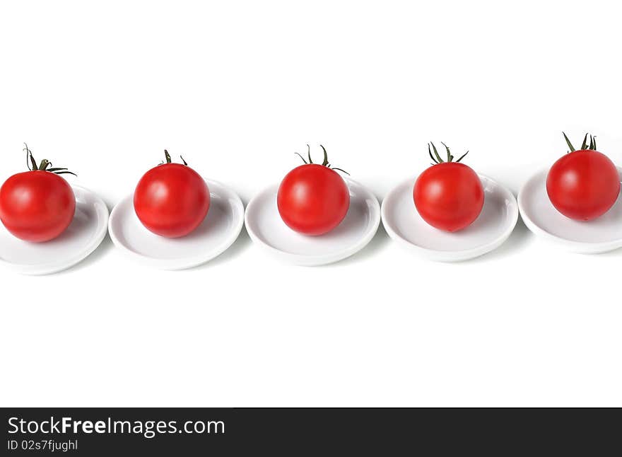 Five organic  tomatoes  on plates